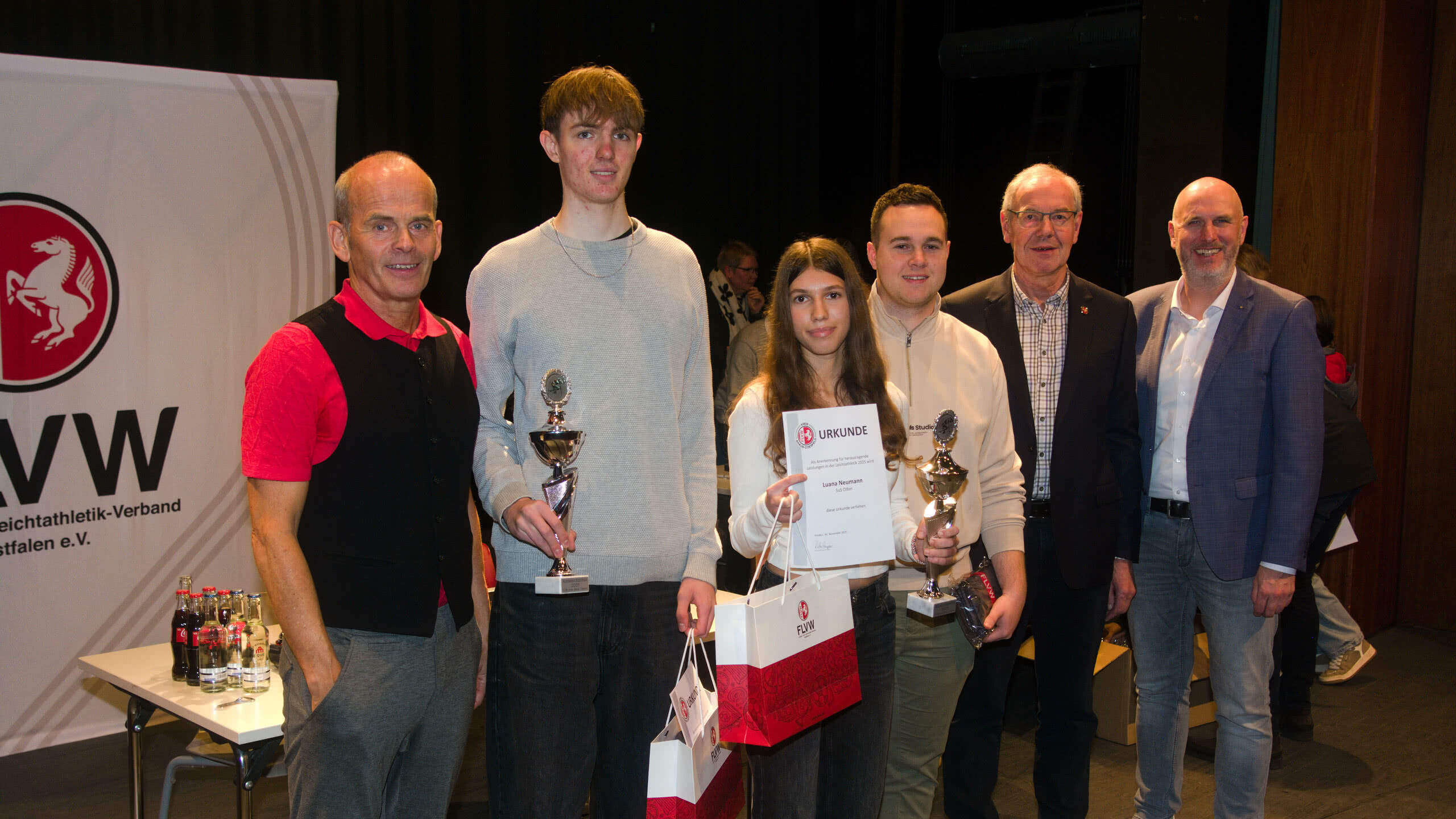 Es freuen sich mit ihren Athleten: Bernd Bohmert (Trainer Arne Hörsting), Arne Hörsting, Luana Neumann, Rik Amann (Trainer Luana Neumann) und die Ehrengäste Bernhard Bußmann (Vorsitzender des Verbandsleichtathletikausschuss) und Markus Thesing als Regionalleiter der Sparkasse Westmünsterland.