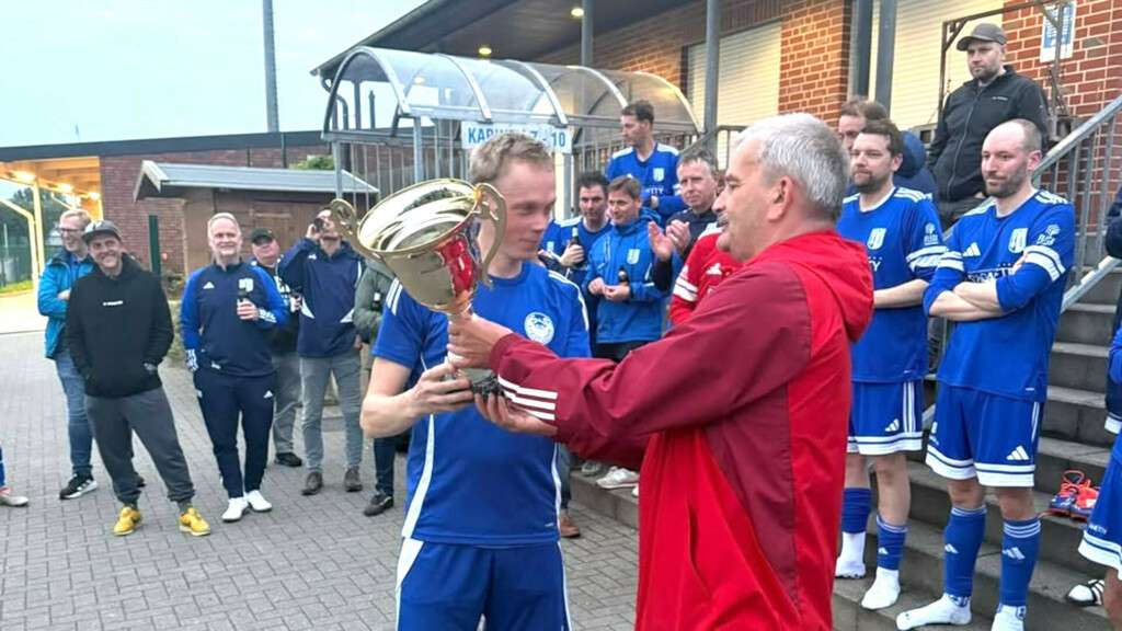 Altherren-Obmann Manfred Nieland übergibt den Ü40-Pokal an den SuS Stadtlohn.