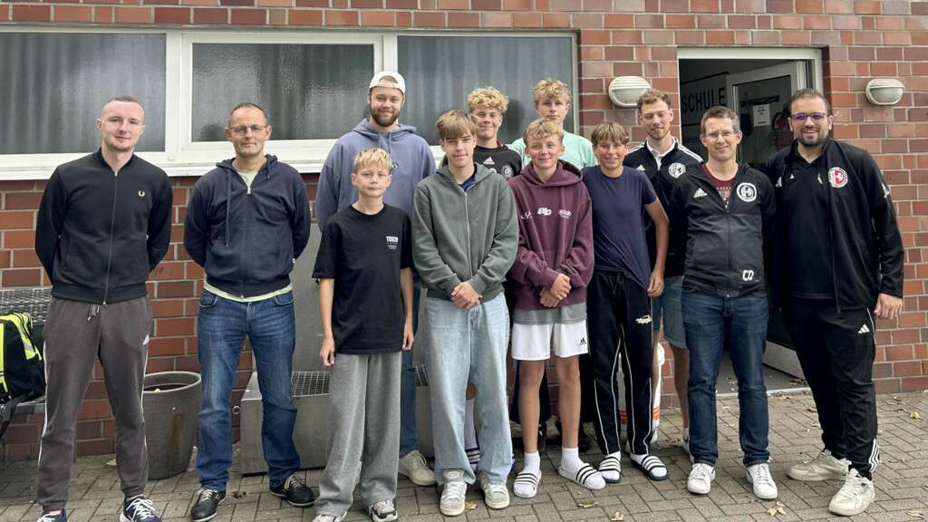 Die neuen Schiedrichter stellen sich zum Abschlussfooto auf der Sportanlage der SG Coesfeld auf